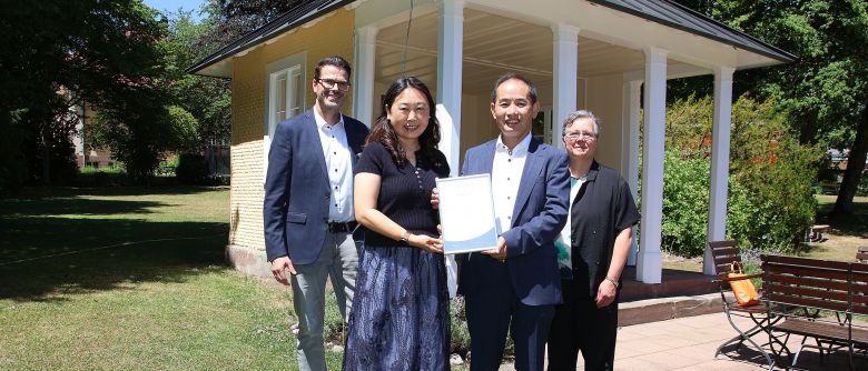Sr. Terno (rechts) und Br. Banholzer (links) haben Qiang Ouyang (2. von rechts) und seine Frau Rong Jin mit einer Urkunde für die langjährige Zusammenarbeit gedankt.